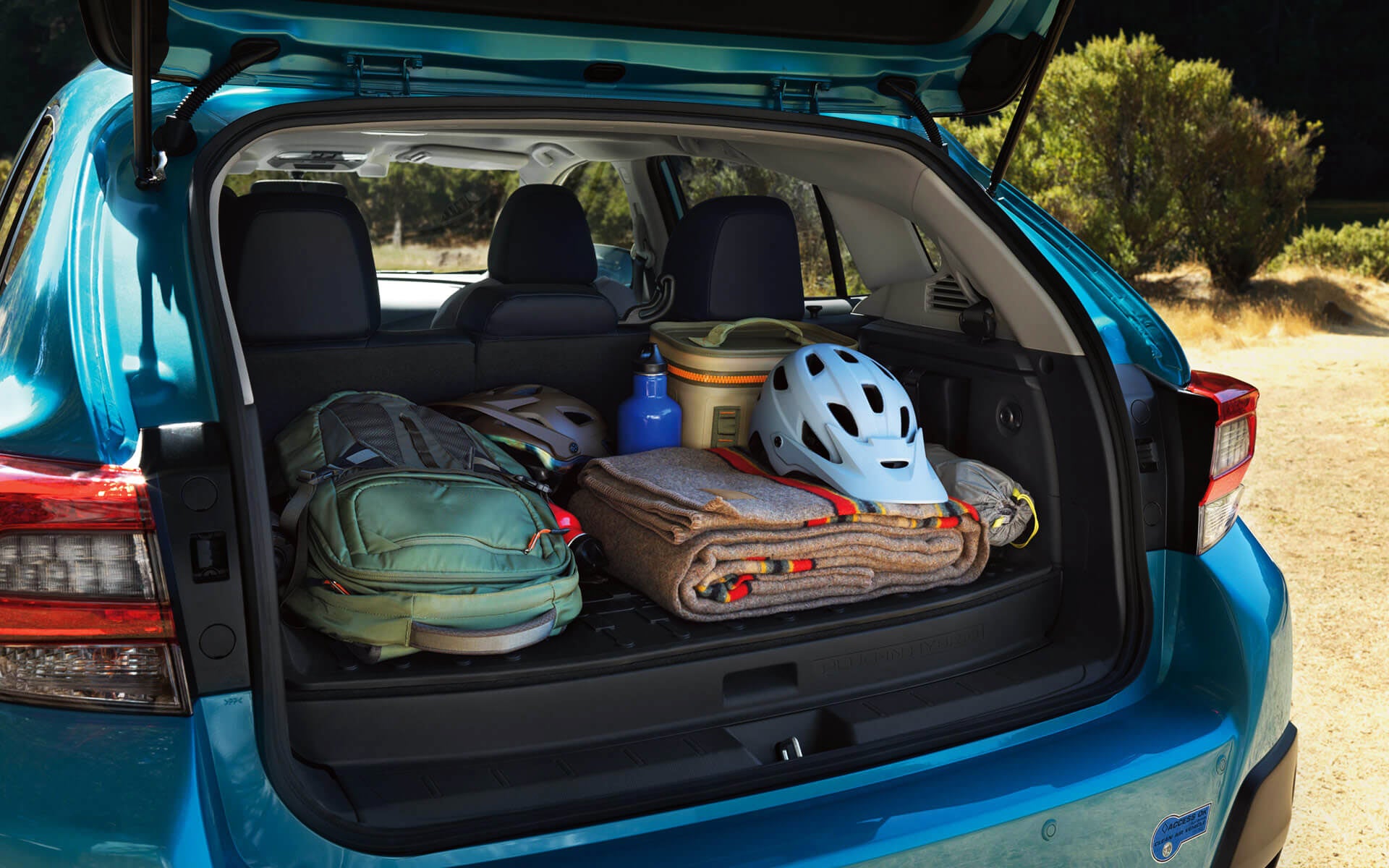 A backpack, blanket, and bike helmet in the rear cargo area of a Crosstrek Hybrid | Valley Subaru of Longmont in Longmont CO