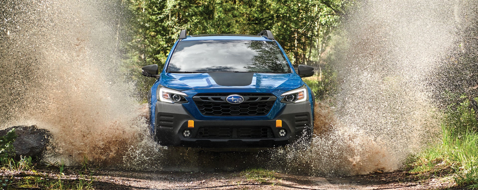 A 2023 Outback Wilderness driving on a muddy trail. | Valley Subaru of Longmont in Longmont CO