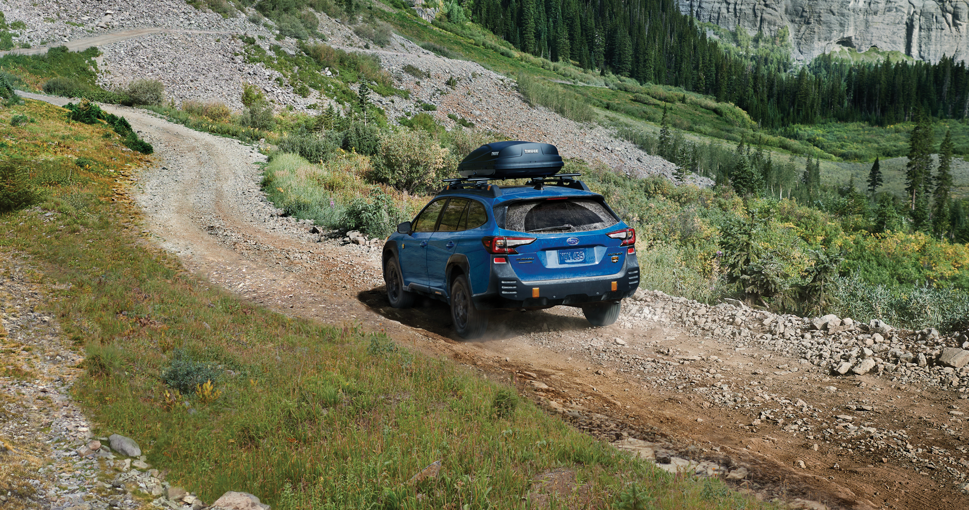 A 2023 Outback Wilderness driving on a trail in the mountains. | Valley Subaru of Longmont in Longmont CO