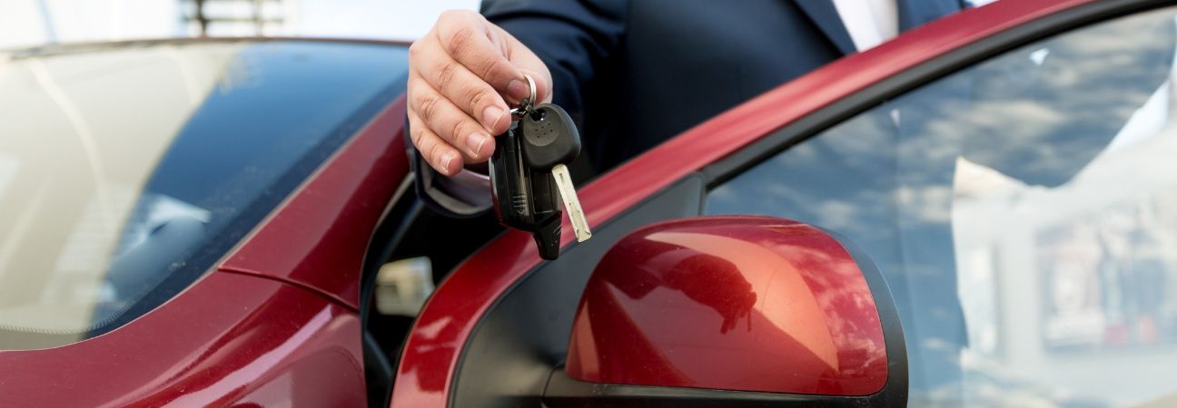 a man holding the keys to his new car