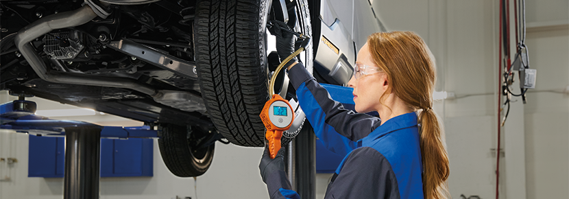 A Subaru technician checking tire pressure. | Valley Subaru of Longmont in Longmont CO