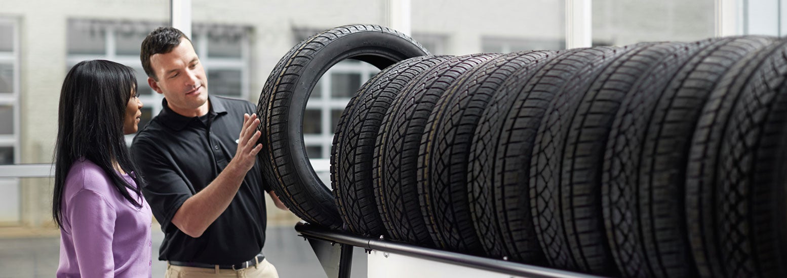 Subaru service representative showing customer a tire. | Valley Subaru of Longmont in Longmont CO